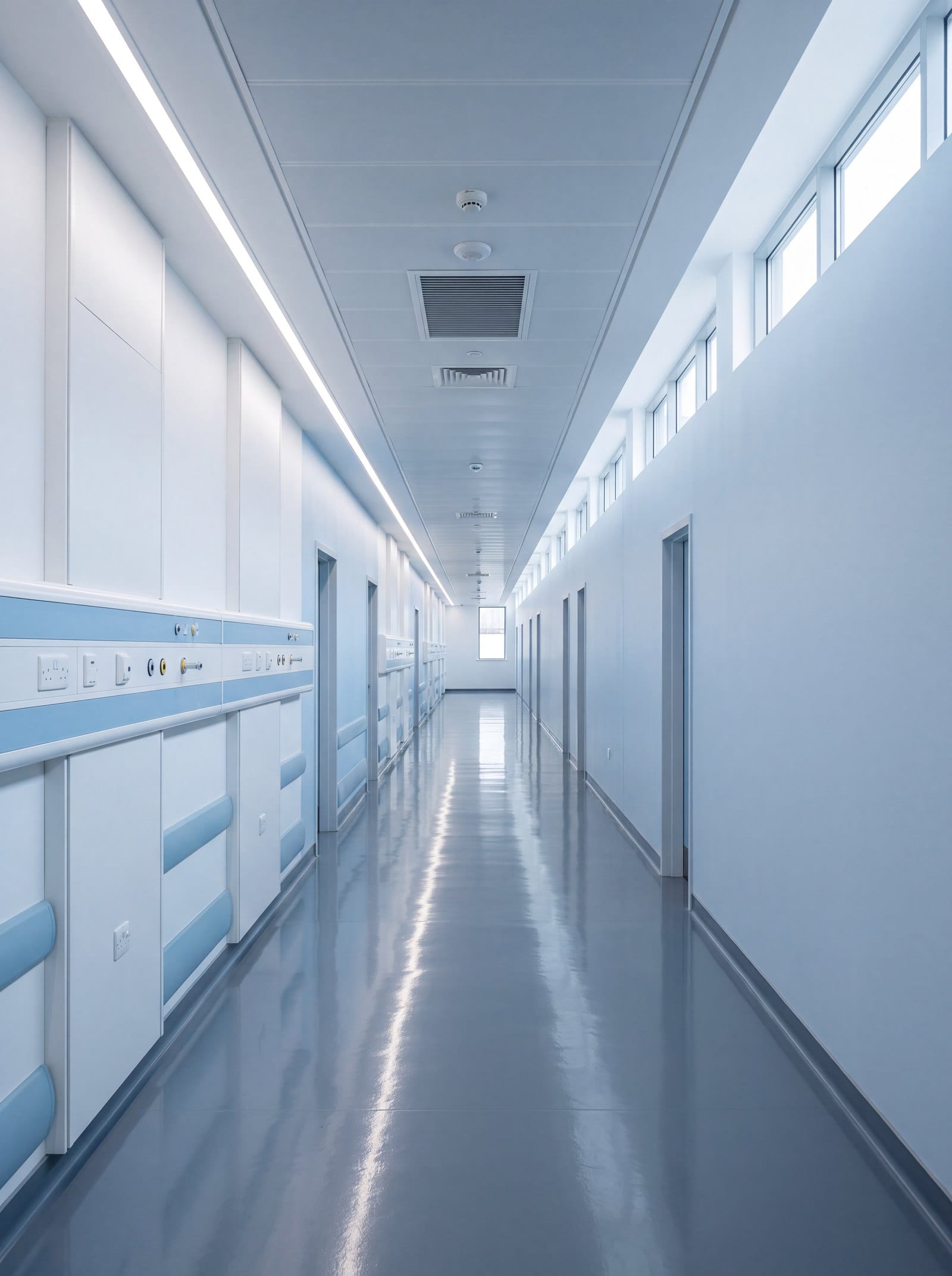 Empty modern hospital corridor with bedhead services along the wall