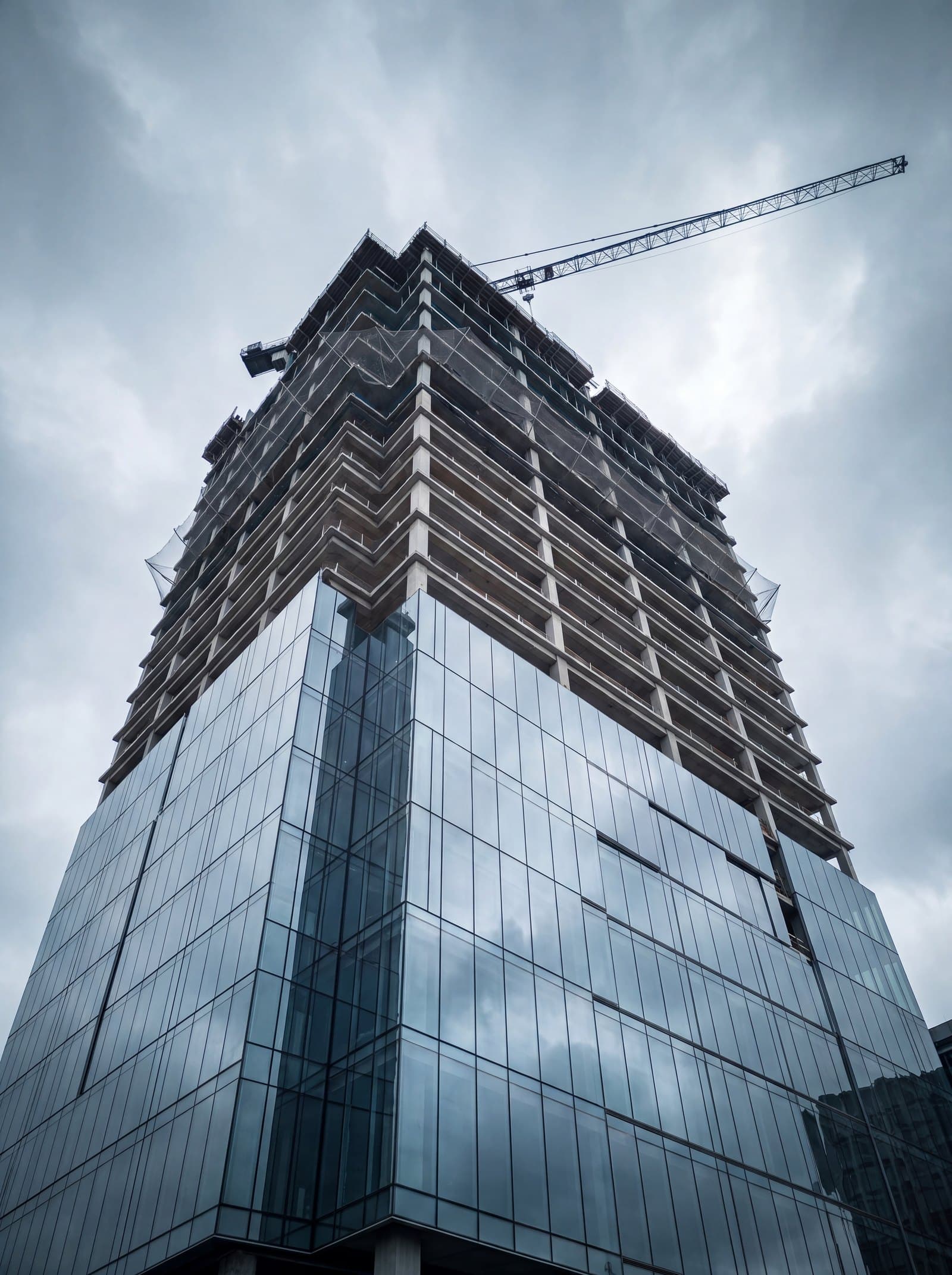 Glass office tower under construction with a tower crane
